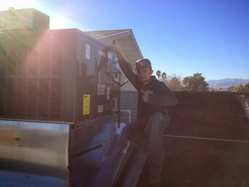 HVAC technician performing Air Duct Cleaning on a rooftop unit in Forest Park